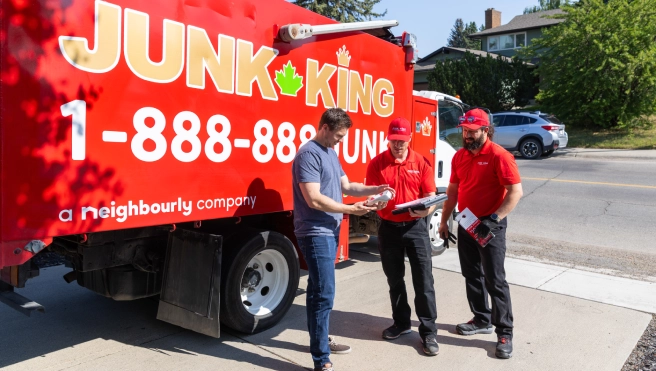 Junk King professionals working by the side of a truck.