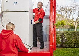 Junk King crew loading refrigerator onto truck.